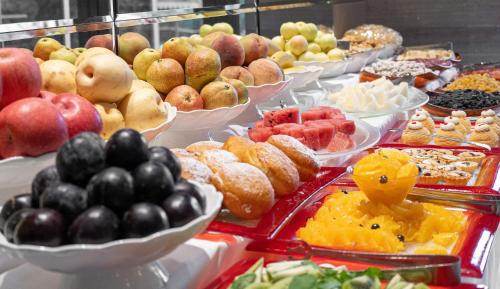 een buffet met verschillende soorten fruit en gebak bij AZIMUT Grand Hotel Tashkent in Tasjkent