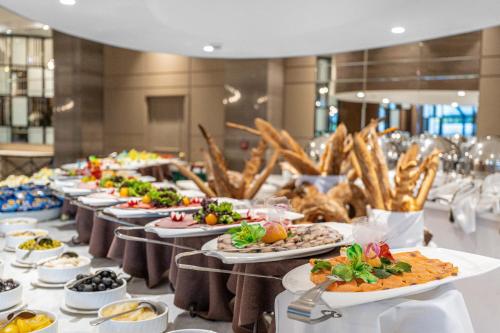 een buffetlijn met borden met eten bij AZIMUT Grand Hotel Tashkent in Tasjkent