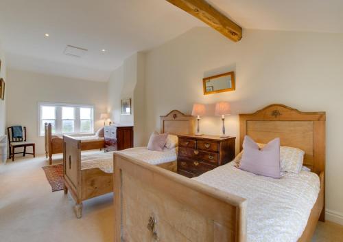 a bedroom with two beds and a desk at Davis Gate Farmhouse in Ribchester
