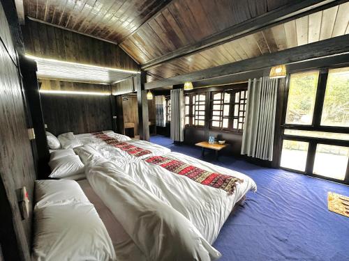 1 dormitorio con 4 camas en una habitación con ventanas en Jessi's House Sapa, en Sa Pa