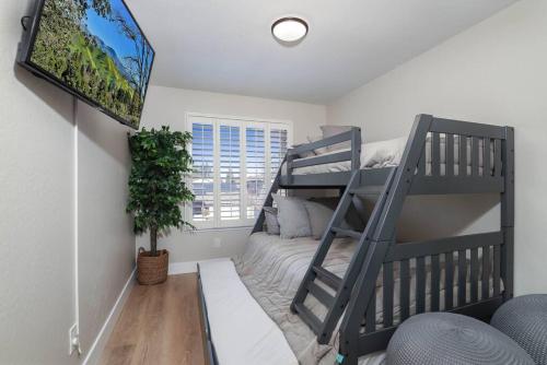 une chambre avec un lit superposé et une télévision dans l'établissement *DESIGNER East Bay Remodel Home*, à Concord