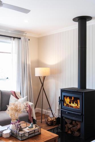 a living room with a fireplace and a couch at Lazy Frog Lodge Mudgee country luxury in Mudgee