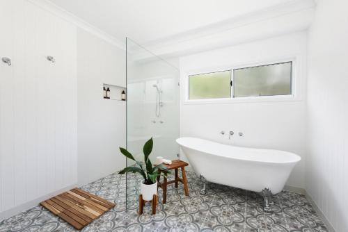 a white bathroom with a tub and a window at Lazy Frog Lodge Mudgee country luxury in Mudgee