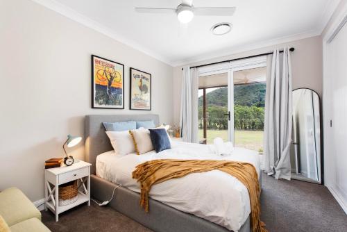 a bedroom with a large bed and a window at Lazy Frog Lodge Mudgee country luxury in Mudgee