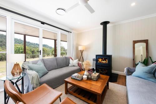 a living room with a couch and a fireplace at Lazy Frog Lodge Mudgee country luxury in Mudgee