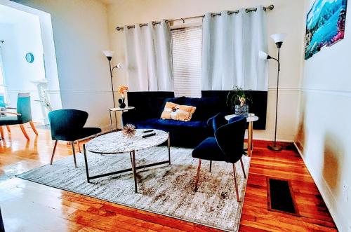 a living room with a blue couch and chairs at Chateau de Woodlawn - Room I - La Tour Eiffel in Chicago