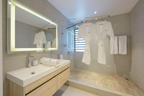 a white bathroom with a sink and a mirror at Otera 2 Penthouse with panoramic view by LOV in Trou aux Biches