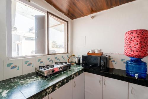 a kitchen with a stove and a microwave at Mystique abode in New Delhi