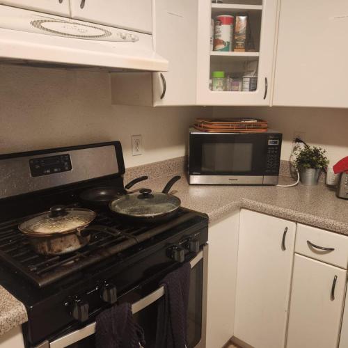 a kitchen with a stove with pots and pans on it at Nearby Beach House in El Segundo