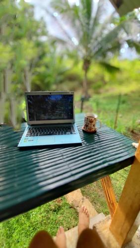 a laptop computer sitting on a picnic table with a cup of coffee at Rose Apartments in Anda