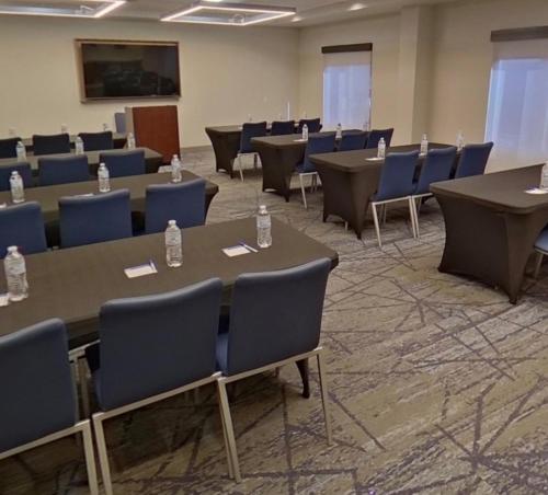 a conference room with tables and blue chairs at Holiday Inn Express & Suites - Tuscaloosa-University by IHG in Tuscaloosa