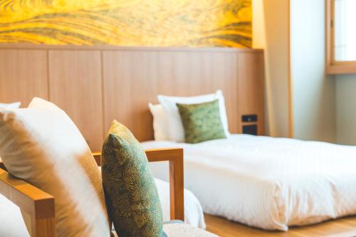 a hotel room with two beds with pillows at KAYA Kyoto Nijo Castle, BW Signature Collection by Best Western in Kyoto