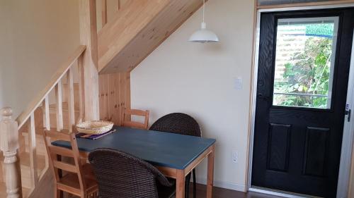 a dining room with a table and chairs and a black door at Sopoong in Jeju