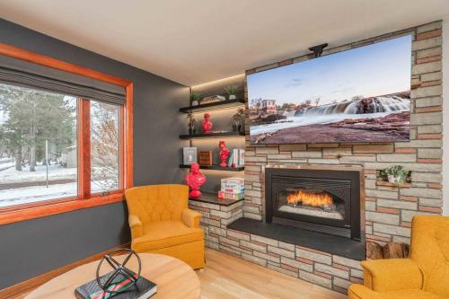 a living room with a fireplace with a large screen at Brick House in Sioux Falls