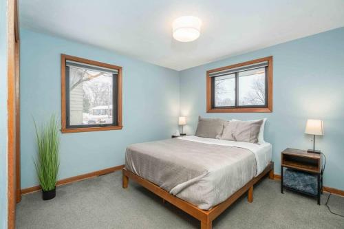 1 dormitorio con 1 cama y 2 ventanas en Brick House, en Sioux Falls