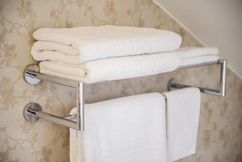 a stack of towels on a towel rack in a bathroom at Sarea-n Bucate (Crama la Salina) in Turda