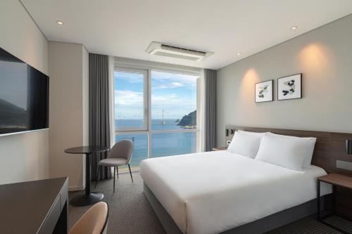 釜山にあるUrbanstay Busan songdo Beachのベッドと大きな窓が備わるホテルルームです。
