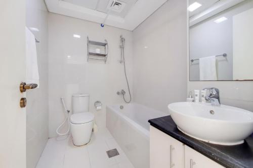 a bathroom with a sink and a toilet and a tub at Primestay - Park Central Studio - Business Bay in Dubai