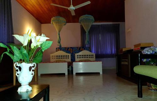 un salon avec un vase et des fleurs sur une table dans l'établissement Mohotti House, à Galle