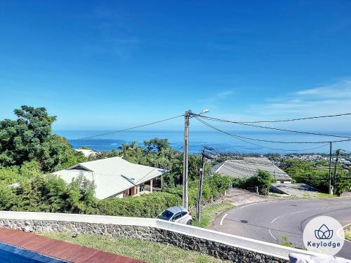a view of a road with houses and the ocean at Villa One - avec piscine - 127m2 - Saint-Paul in Saint-Paul