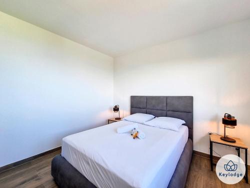a bedroom with a large white bed and two tables at Villa One - avec piscine - 127m2 - Saint-Paul in Saint-Paul