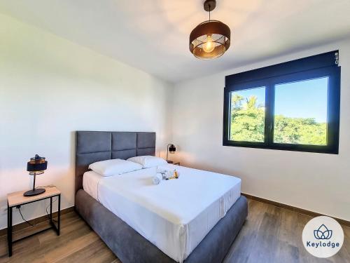a bedroom with a large bed and a window at Villa One - avec piscine - 127m2 - Saint-Paul in Saint-Paul