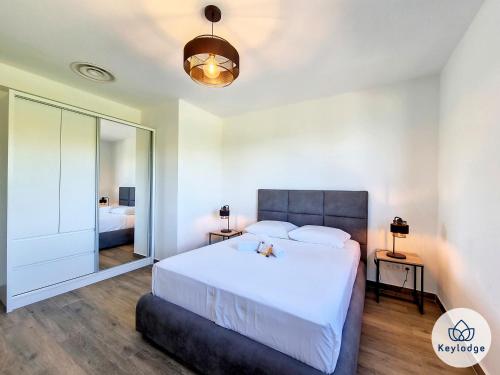 a bedroom with a large white bed and a mirror at Villa One - avec piscine - 127m2 - Saint-Paul in Saint-Paul