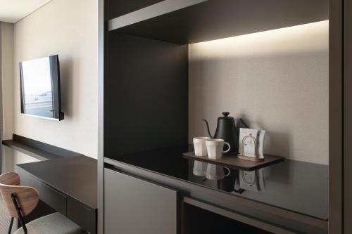 a mirror in a room with a table and a chair at Urbanstay Busan songdo Beach in Busan