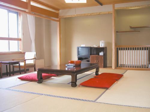 a living room with a coffee table and a television at Shiga Kogen Lodge in Yamanouchi