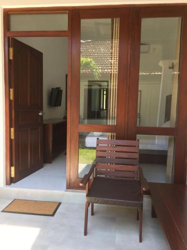 a wooden bench sitting in front of a door at Hiri Point Villa in Dickwella