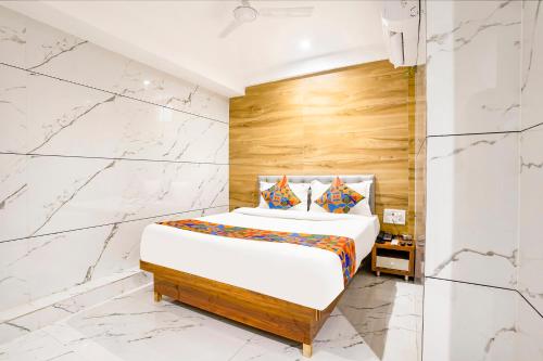 a bedroom with a king sized bed with marble walls at FabHotel Shubham Inn - Nr Jain Mandir, Bhandup West in Mumbai
