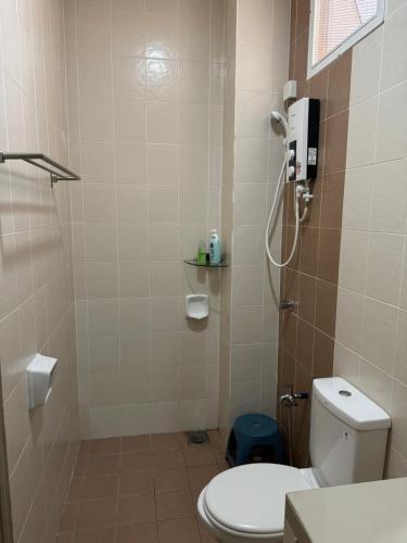 a small bathroom with a toilet and a shower at Rumah Singgah Taman Belia Antarabangsa in Ayer Keroh