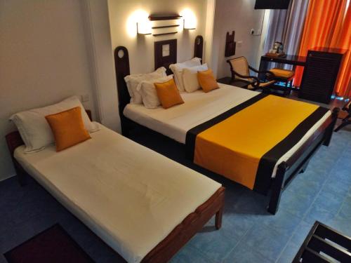 a hotel room with two beds in a room at DALAWELLA BEACH RESORT in Unawatuna