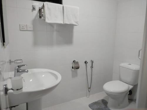 a white bathroom with a toilet and a sink at DALAWELLA BEACH RESORT in Unawatuna