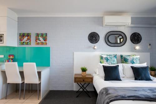 a bedroom with two beds and a table and a desk at Batemans Bay Studio Escape with Lush Vista in Batehaven