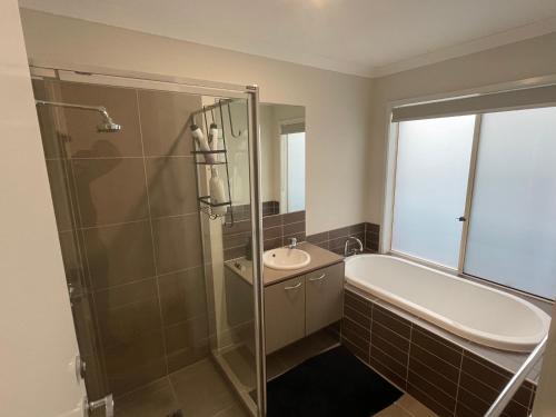 a bathroom with a shower and a sink and a toilet at Comfy Newly Furnished Queen bedroom in Point Cook