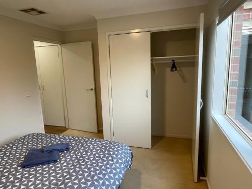 a bedroom with a bed with a blue shirt on it at Garden View - Newly furnished Queen bedroom in Point Cook