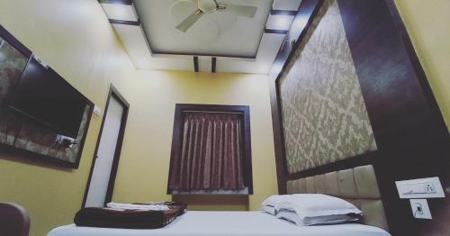 a room with two beds and a ceiling at Hotel Sree Durga in Kolkata