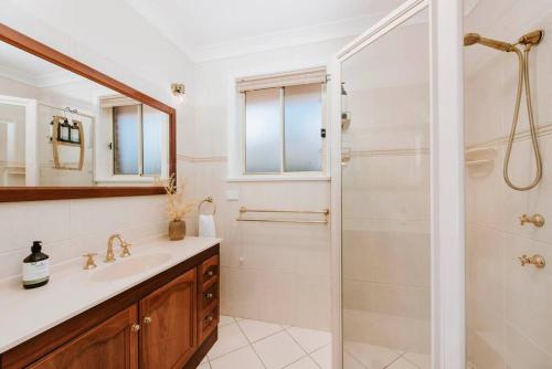 a white bathroom with a shower and a sink at Macquarie Manor - Experience Grand Country Living in Mudgee