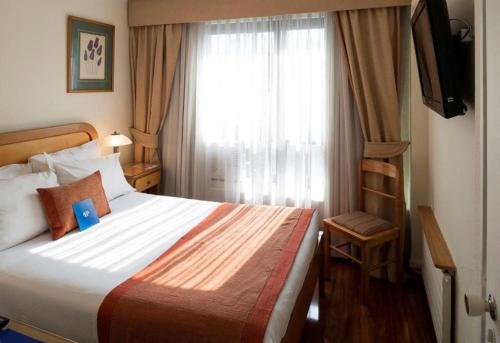 Habitación de hotel con cama y ventana en Hotel Presidente, en Santiago