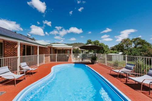 a swimming pool with lounge chairs and a house at Macquarie Manor - Experience Grand Country Living in Mudgee