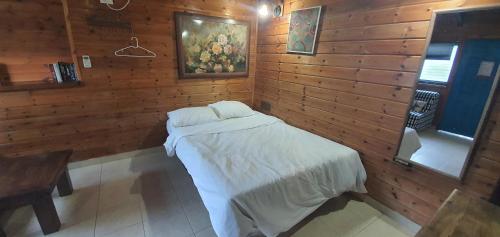 a bedroom with a bed in a wooden wall at The Lake House in Migdal