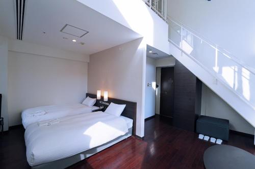um quarto com 2 camas e uma escada em KOKO HOTEL Sendai Kotodai Park em Sendai
