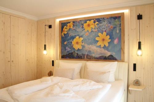 Un dormitorio con una cama con una pintura encima. en Mein Königreich en Garmisch-Partenkirchen