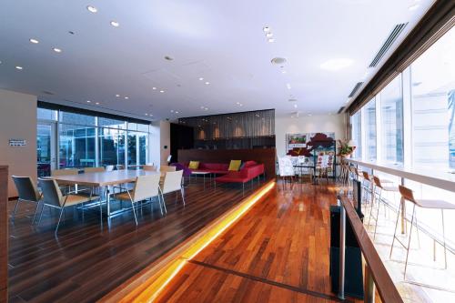 a dining room and living room with a table and chairs at KOKO HOTEL Sendai Kotodai Park in Sendai