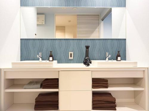 een badkamer met 2 wastafels en een spiegel bij AMP FLAT Gion in Fukuoka