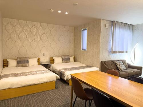 een hotelkamer met 2 bedden en een tafel bij AMP FLAT Gion in Fukuoka