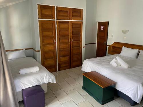 a bedroom with two beds and a table in it at Eagles View Kungwini in Erasmus
