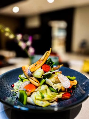 a blue plate of food with vegetables on a table at Distrikt 9 in Palakkad
