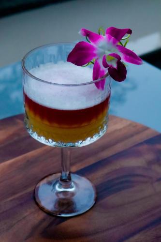 a wine glass with a flower in it on a table at Distrikt 9 in Palakkad